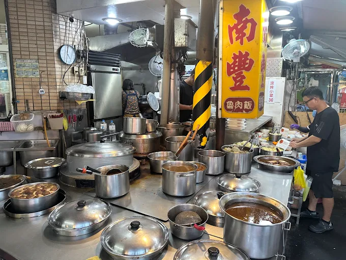 高雄南豐魯肉飯店面，滿桌大鍋滷汁與小菜